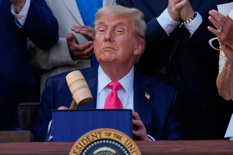 Donald Trump held a gavel that House Speaker Mike Johnson had handed him after the president signed his signature bill of tax breaks and spending cuts at the White House on July 4 in Washington, surrounded by Republican members of Congress.